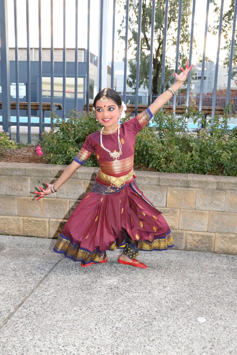 Shriya dancing outdoors in maroon costume
