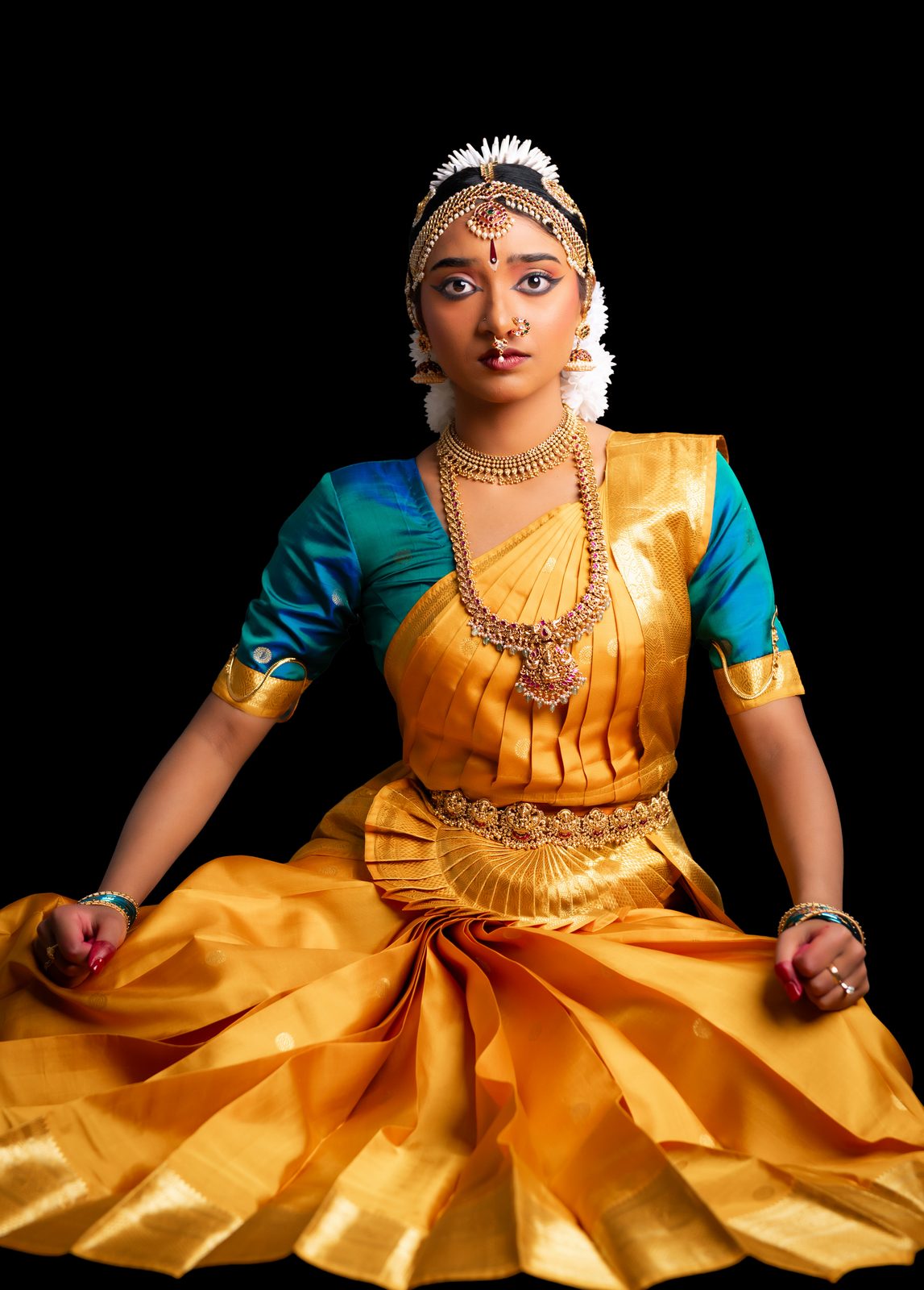 Shriya seated facing forward, gold costume