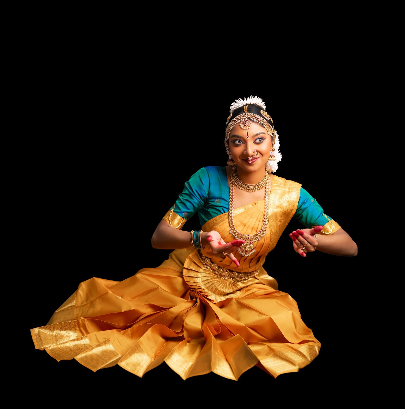 Shriya Ramanaharan seated in Bharathanatyam costume, skirt fanned wide